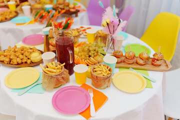 A set table with snacks. french fries, mini burgers and nuggets. 