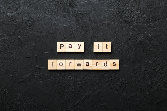Pay It Forward word written on wood block. Pay It Forward text on cement table for your desing, concept
