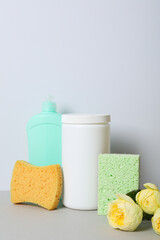 Detergents with flowers and washcloths on a light background