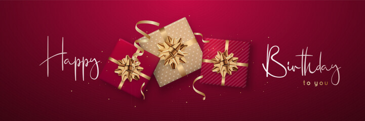Red themed birthday gifts with golden bows. Horizontal festive banner.