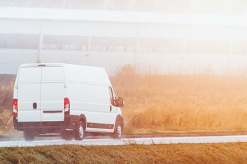 delivery van carries parcels along a sunlit road, ensuring timely service and customer satisfaction.