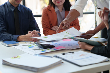 Fototapeta premium Financial analyst analyzes business finance reports on laptop and graph documents during corporate meeting discussions showing successful teamwork, business meeting ideas, marketing.