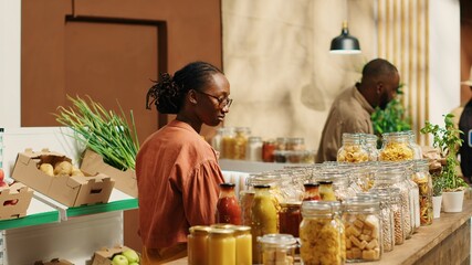 African american client examines bio homemade bulk products, looking to buy natural ethically...