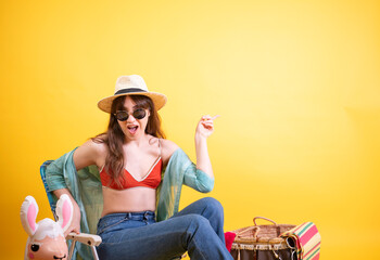 Excited Young Latina Pointing and Laughing on Yellow Background