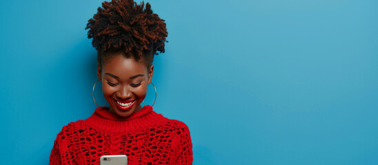 Portrait of smiling african american woman using smartphone isolated on blue background, wearing red sweater with copy space for your text message or promotion banner. ,copy space, High quality,