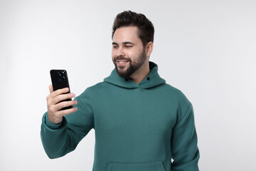 Happy young man using smartphone on white background