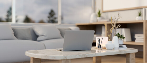 A laptop computer on a luxury white marble coffee table in a comfortable contemporary living room.