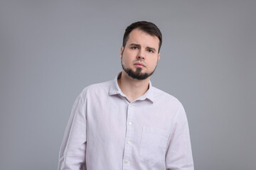 Portrait of sad man on grey background