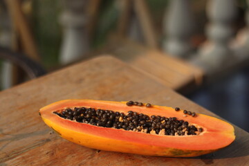 A half of ripe papaya with seeds on the table