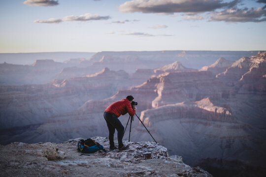 Male photographer with tripod at edge of Grand Canyon, Arizona
