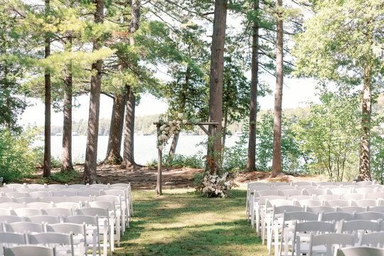 Lakeside wedding ceremony setup with floral arch