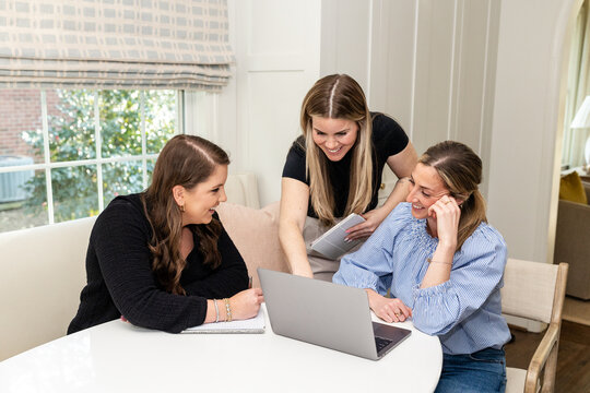 A focused group of women in a team meeting, working in a home office