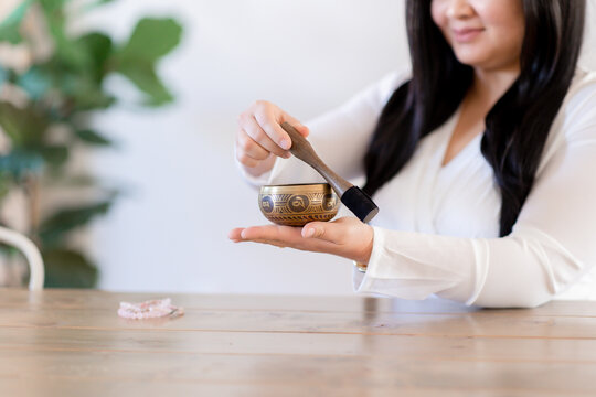 Asian woman hand playing Tibetan singing bowl for meditation