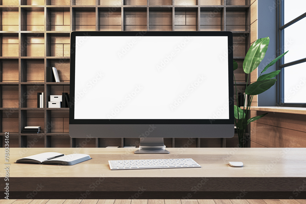Poster Close up of designer office workplace with empty white computer monitor, window with city view and wooden shelves in the background. Mock up, 3D Rendering.