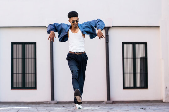 Happy joyful carefree guy urban dancing outside.