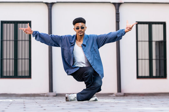 Skilled confident guy dancing outside looking at camera.
