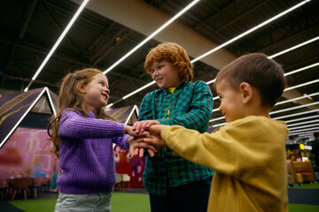 Happy preschool children having fun in play area standing in circle - 780340744
