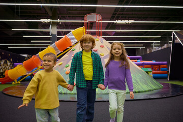 Happy preschool children having fun in play area standing in circle - 780340747
