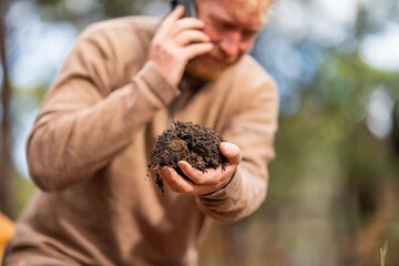 regenerative organic farmer, taking soil samples and looking at plant growth in a farm. practicing sustainable agriculture in australia
