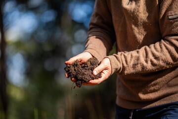 agronomist on a farm practicing agronomy holding soil, doing soil tests in her home laboratory. Looking at soil life and health