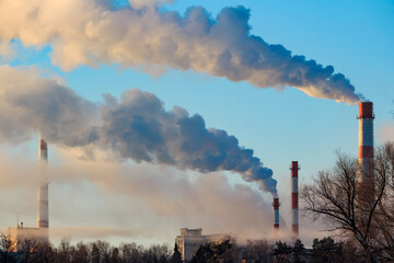 View of tall chimneys smoking in puffs of steam, industrial landscape