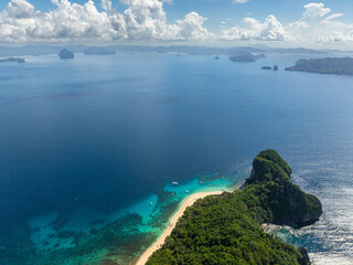 Tropical Beach with ocean waves and boats. Helicopter Island. El Nido, Philippines.