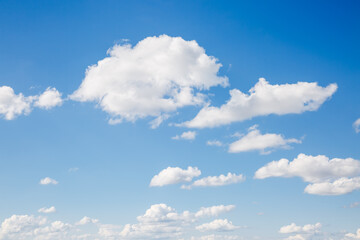Naklejka na ściany i meble Picturesque sky background with white fluffy clouds.