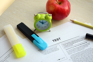 Blank educational test for students lies on table in classroom with pen close up
