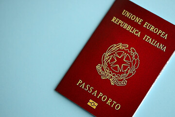 Italian passport on blue background close up. Tourism and citizenship concept