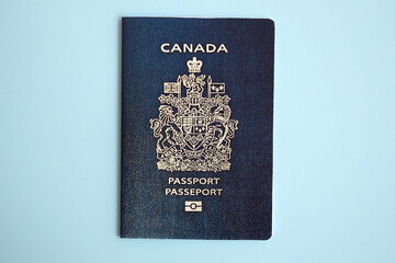 Naklejka premium Canadian passport on blue background close up. Tourism and citizenship concept
