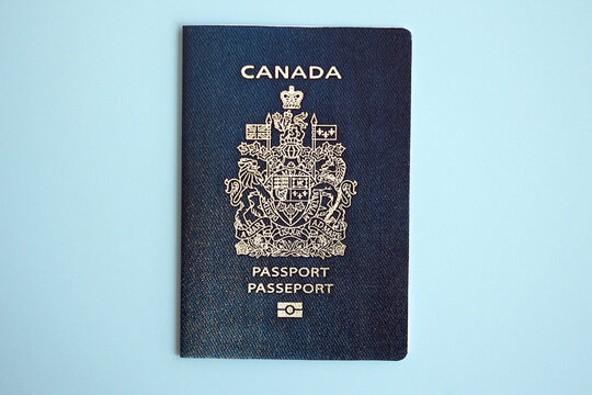 Canadian passport on blue background close up. Tourism and citizenship concept