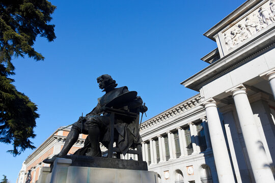 Impressive bronze statue situated at the entrance of the renowned Prado Museum under a clear sky