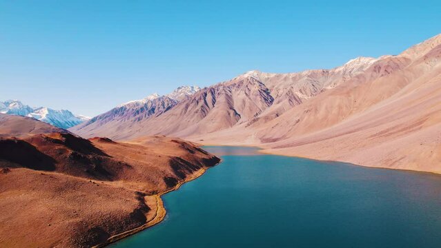 4K aerial shot of beautiful Chandratal lake surrounded by snow capped Himalaya mountains in Spiti Valley, India. Travel and summer vacation  concept. Mountain lake during sunny day.