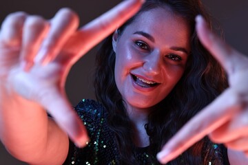 Portrait of beautiful young woman on color background with neon lights