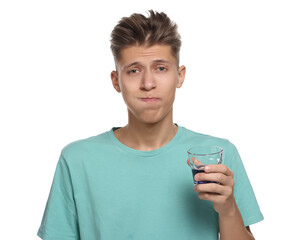 Young man using mouthwash on white background