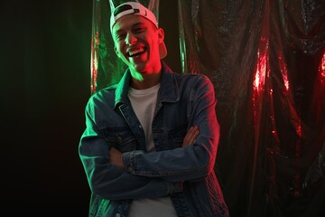 Happy young man on dark background in neon lights