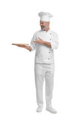 Happy chef in uniform pointing at wooden board on white background