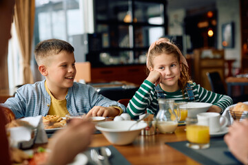 Happy kids enjoying in family breakfast in restaurant at hotel.