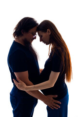 Photo of cheerful young man standing with his pregnant woman isolated over white background wall. beautiful young couple expecting baby standing together and touching belly 