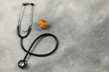 Endocrinology. Stethoscope and model of thyroid gland on grey table, top view. Space for text