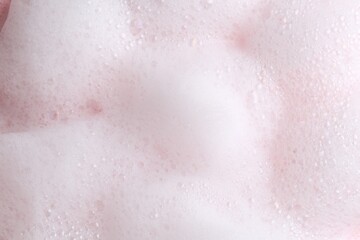 Fototapeta premium White fluffy foam as background, top view