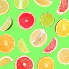 Many different fresh citrus fruits in air on light green background