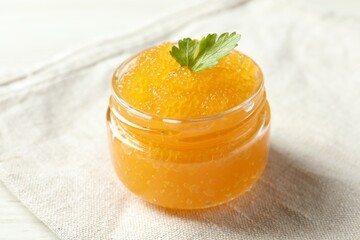 Fresh pike caviar in glass jar on table, closeup