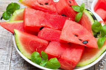 watermelon slices. on a gray table there is a large white plate with slices of ripe watermelon, top view, close-up, fruit concept
