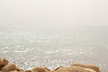 Fototapeta na wymiar Mediterranean sea on a cloudy day. stones in the foreground