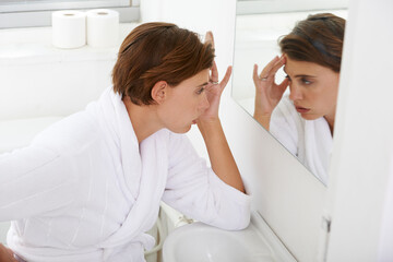 Woman, mirror and headache pain in bathroom for morning sickness or hangover, reflection or...