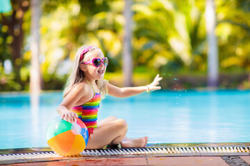 Child in swimming pool with ball. Kids swim. - 780395507