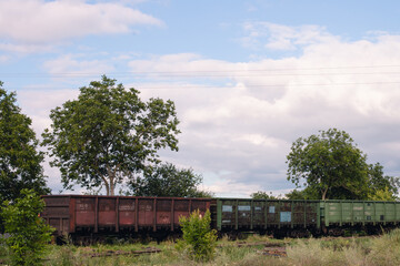 A freight train with wagons is moving along the rails