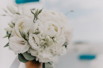 A bouquet of white flowers is being held by a person. The flowers are arranged in a way that they look like they are in a vase. The bouquet is the main focus of the image.