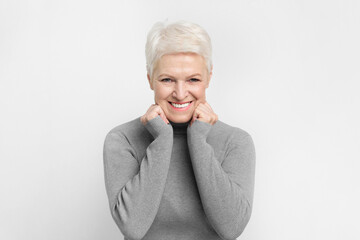 Cheerful senior woman with hands on face